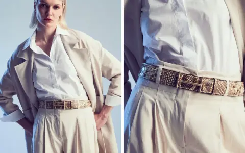 Modello indossa una cintura in pelle di serpente, un accessorio di tendenza che completa un look elegante con pantaloni beige e blazer.