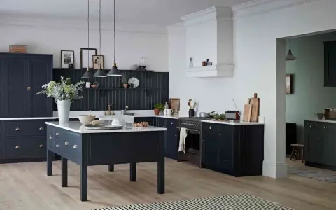 Elegancka kuchnia z ciemnogranatowymi, **czarnymi meblami kuchennymi**. Centralna wyspa i zabudowa tworzą spójną całość.