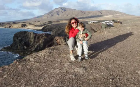 Mamma e bambino felici a Lanzarote con bambini, con vista sulle scogliere e montagne vulcaniche.