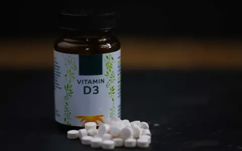 Flasche mit Vitamin D3 und Pillen. Wann einnehmen? Am besten mit einer Mahlzeit, um die Aufnahme zu verbessern.