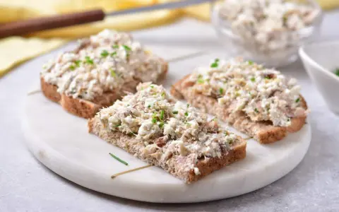 Pyszna pasta z makreli i twarogu na ciemnym pieczywie, posypana szczypiorkiem. Idealna na szybkie śniadanie lub przekąskę.