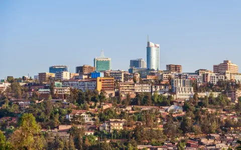Widok na Kigali, Rwanda. Miasto rozwija się, a nowoczesne budynki górują nad zielonymi wzgórzami. Czy Rwanda jest bezpieczna? Obraz sugeruje spokój i postęp.