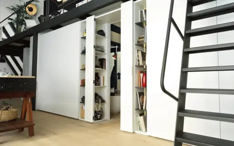 Divisori ambienti interni con librerie a scomparsa, ideali per organizzare e definire spazi in stile moderno.