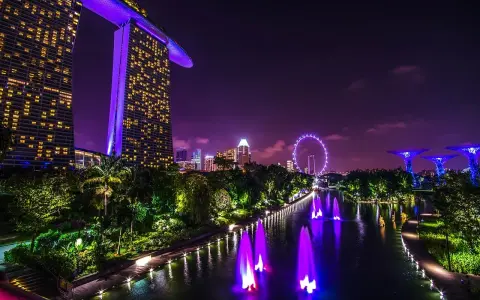 Nocny Singapur z Marina Bay Sands, diabelskim młynem i świetlistymi drzewami. Marzenie o wizie do Singapuru staje się rzeczywistością.