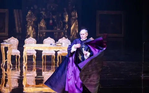 Aktor w purpurowej pelerynie, w teatralnej scenografii, budzi pytanie: misterium co to?