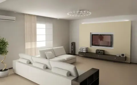 Nowoczesny salon z białymi meblami i telewizorem na ścianie. Oświetlenie niskiego sufitu tworzy przytulną atmosferę.
