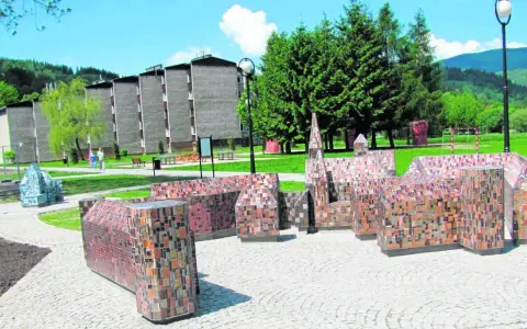 Miniatury budowli z mozaiki, ciekawe wisła atrakcje turystyczne. W tle budynki mieszkalne i zalesione wzgórza.