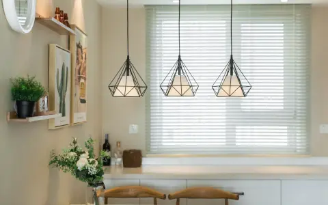 Trzy wiszące lampy w kształcie diamentu nad stołem w salonie.