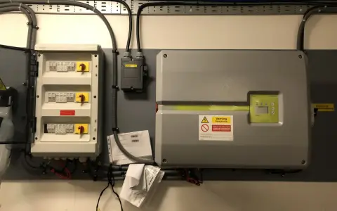 Elcentral med dc-brytare för solceller, uppfyller krav. En växelriktare och dokumentation syns också.