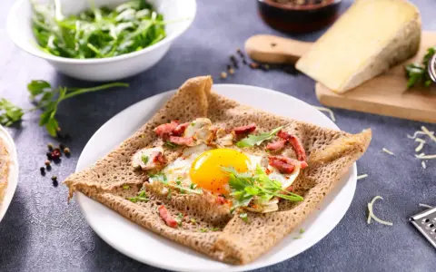 Une galette de sarrasin garnie d'un œuf au plat, de lardons et de champignons. Un délice pour un petit-déjeuner ou un brunch.