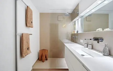 Bagno moderno con lavabo bianco, doccia a pioggia e dettagli in legno. Ottime idee per arredare bagno con stile minimalista.
