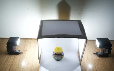 Słoik Marmite w domowym namiocie bezcieniowym DIY, oświetlony lampami błyskowymi.