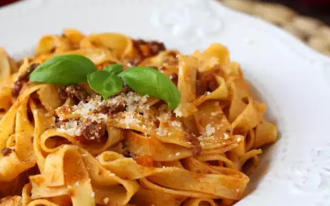 Breite Bandnudeln mit herzhaftem Ragout Bolognese, garniert mit frischem Basilikum und Parmesan. Ein Klassiker, der immer schmeckt.