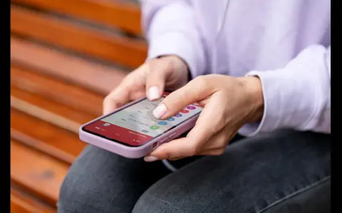Dłonie kobiety obsługują smartfon, czując subtelne wibracje haptyczne przy każdym dotknięciu ekranu.