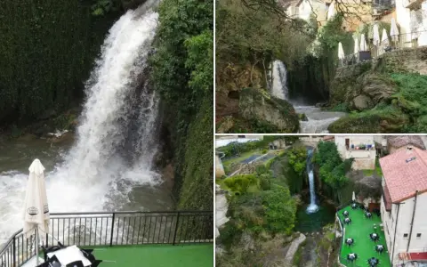 Cascada y terrazas con mesas junto a piscinas naturales en Burgos. Paisaje verde con casas rurales y agua cayendo.