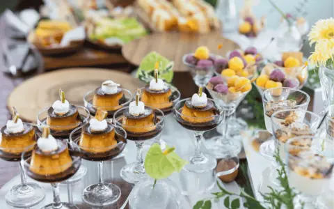 Köstliche kleine Karamellpudding-Desserts mit Sahne und Früchtebällchen – tolle Buffet Ideen für jede Feier.
