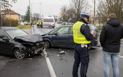 Policjant spisuje sprawcę wypadku. Zniszczone auta i karetka na sygnale świadczą o tym, że doszło do tragedii, być może przez jazdę pod wpływem.
