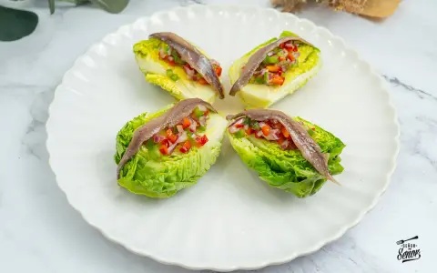 Cuatro cogollos de Tudela rellenos de pimientos y cebolla, coronados con anchoas. Frescura y sabor en cada bocado.