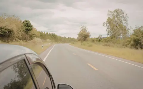 Vista desde un coche en una carretera rural. ¿Cuántos km dura un coche? Depende de su mantenimiento y el camino.