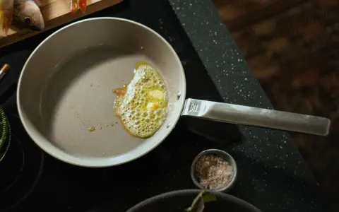 Butter schmilzt in einer beschichteten Pfanne, bereit für Fisch. Die Pfanne ist leicht zu reinigen.