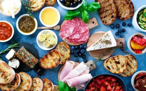 Eine köstliche italienische Vesperplatte mit Salami, Käse, Brot, Oliven und eingelegtem Gemüse.
