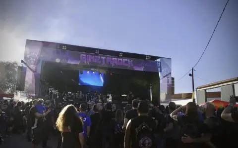 Multitud disfrutando del concierto de gineta rock bajo un cielo azul.