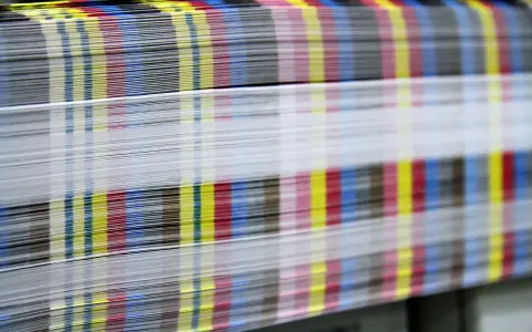 Kolorowe paski CMYK na krawędziach papieru świadczą o pracy w branży poligraficznej.