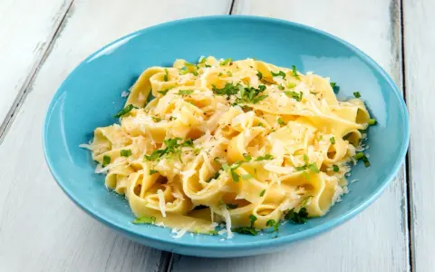Fettuccine al burro e parmigiano, uno dei sughi per pasta più semplici e gustosi, guarnito con prezzemolo fresco.