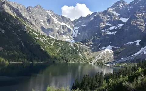 Majestatyczne góry otaczają spokojne Morskie Oko, odbijając w swojej tafli skaliste szczyty i zielone lasy.