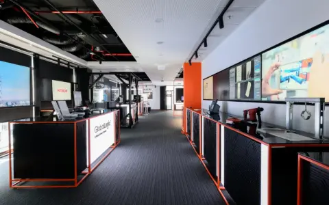 Nowoczesne biuro GlobalLogic, firmy z grupy Hitachi, z ekranami prezentującymi technologie.