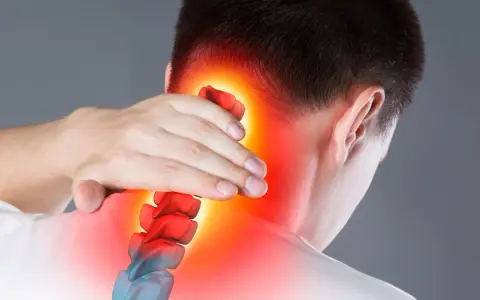 Mann hält sich den Nacken, rote Hitze zeigt Schmerzen im Hinterkopf. Mögliche Ursache: Kopfschmerzen, Tumor.