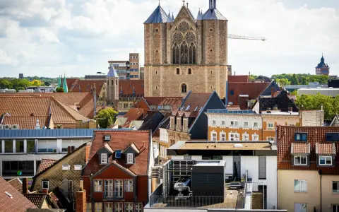 Blick über Dächer auf eine Kirche. Über den Austritt aus der Kirche und steuerliche Folgen wird nachgedacht.