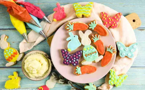 Bunte Osterkekse in Hasen-, Karotten- und Schmetterlingsform, bereit für ein einfaches Osterkekse Rezept. Spritzbeutel mit Zuckerguss liegen bereit.