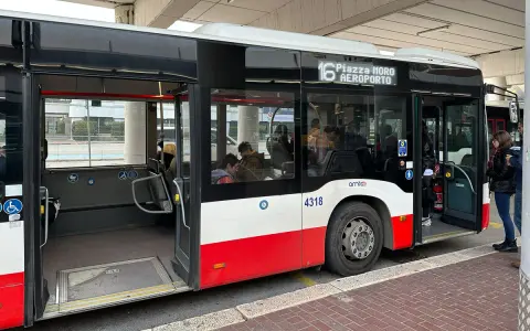 Autobus linii 16 do lotnisko w Bari czeka na pasażerów. W środku siedzą ludzie, drzwi są otwarte.