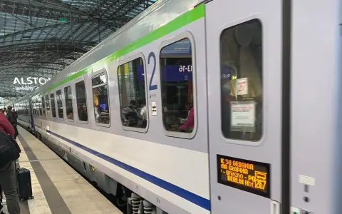 Pociąg IC 58 Gedania z Gniezna do Berlina stoi na peronie. Widać pasażerów w środku.