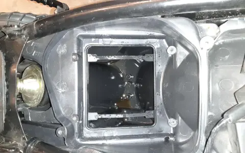 Wnętrze obudowy filtra powietrza motocykla, widoczna odma silnika z olejem.