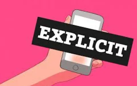 Mano che tiene uno smartphone con la scritta "EXPLICIT". Immagine che allude a esempi di sexting.