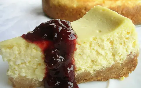 Pyszny sernik z serka wiejskiego polany wiśniową konfiturą, na kruchym spodzie.