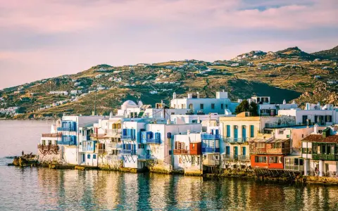 Charming waterfront houses with blue shutters, a classic view of places in Greece to visit.