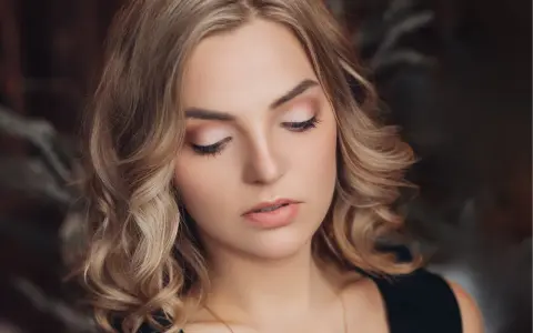 Delikatny makijaż na święta podkreśla urodę kobiety z blond włosami.