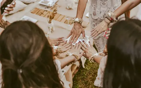 Dłonie ozdobione tatuażami "Team Bride" i bransoletkami z kwiatów. Wspaniałe panieńskie pomysły na celebrację!
