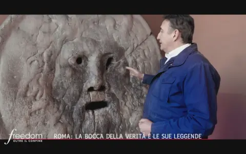 Un uomo indica la Bocca della Verità a Roma, un'antica scultura che si dice morda la mano dei bugiardi. Il suo significato è legato alla giustizia e alla verità.