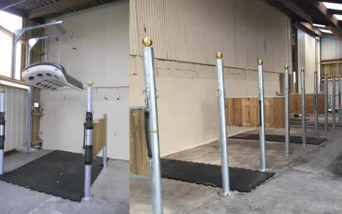 Aménagement d'une **dimension aire de pansage chevaux** avec tapis antidérapants et poteaux de contention. Un système de levage est visible.