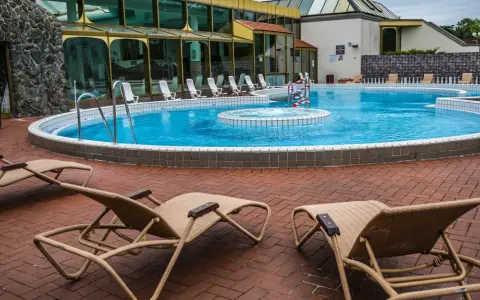 Entspannung pur an der Niederrhein Therme Mattlerbusch: Liegestühle laden zum Verweilen am blauen Pool ein.