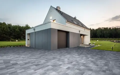 Nowoczesne projekty kostki brukowej wokół domu tworzą elegancką nawierzchnię podjazdu i tarasu, podkreślając architekturę.