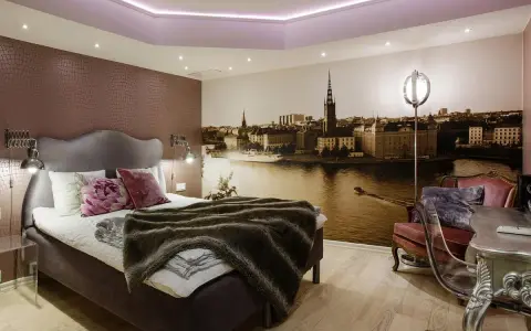 Ett mysigt rum med en stor säng och en fototapet av Stockholm. Perfekt för ditt vandrarhem i Sigtuna.