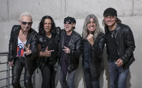 Les membres de Scorpions posent ensemble, vêtus de cuir, prêts à enflammer la scène.