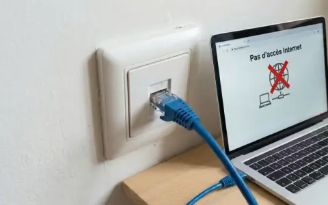 Câble RJ45 branché sur une prise murale, mais l'ordinateur affiche "Pas d'accès Internet". Problème de connexion réseau, peut-être un switch RJ45 sans alimentation.