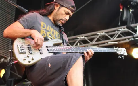 Robert Trujillo z zespołu gra na basie, skupiony na występie.