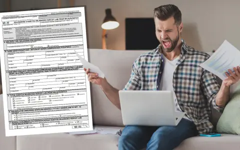 Mężczyzna z wściekłą miną trzyma dokumenty i laptopa, próbując zrozumieć formularz SD-Z2.